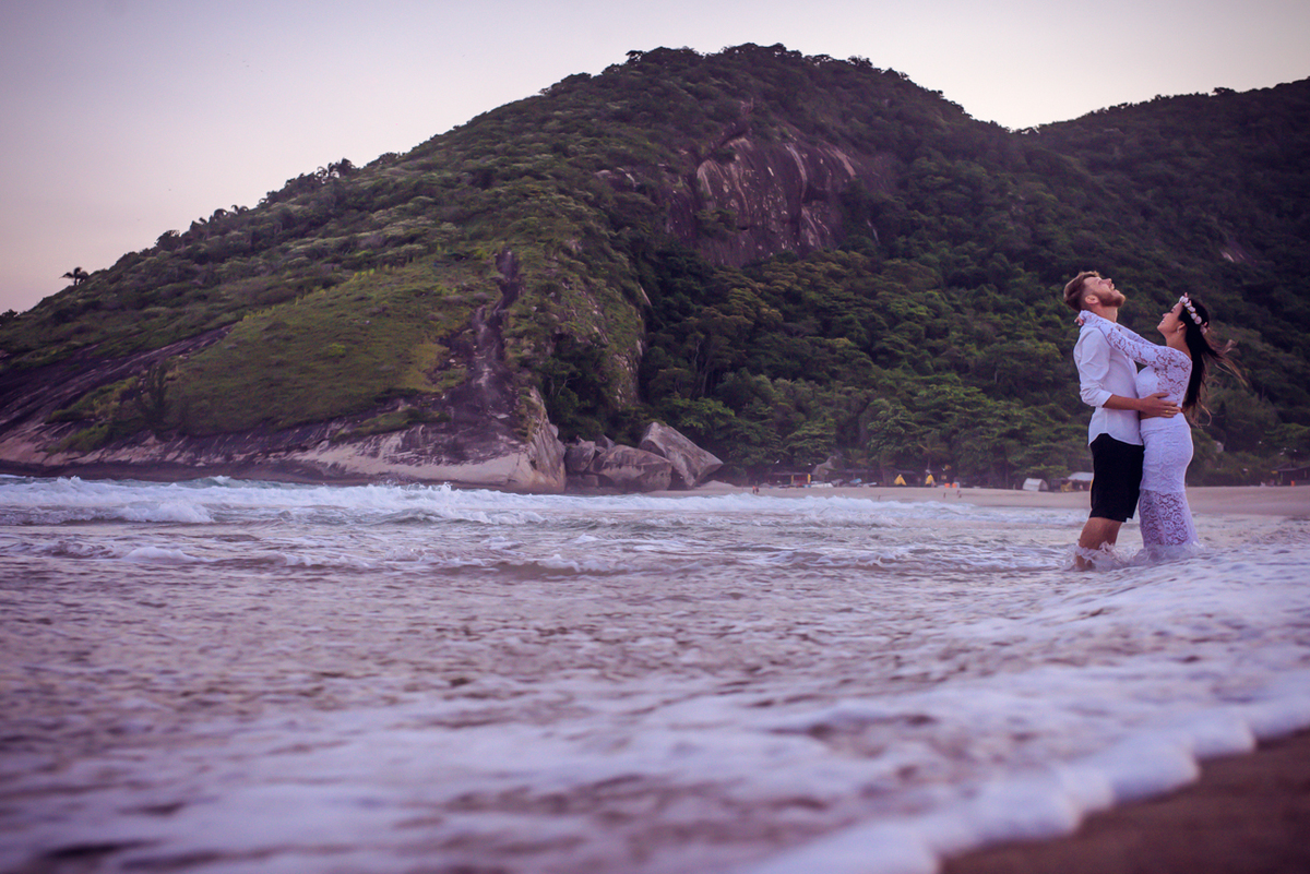 foto do casal se abraçando na beira da praia