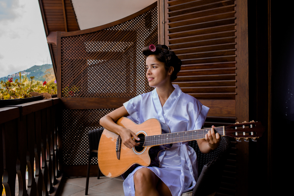 Noiva tocando violão na sacada do hotel em teresópolis
