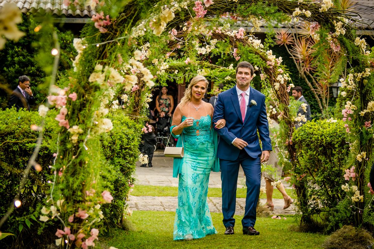 Mãe entrando com o noivo no corredor florido
