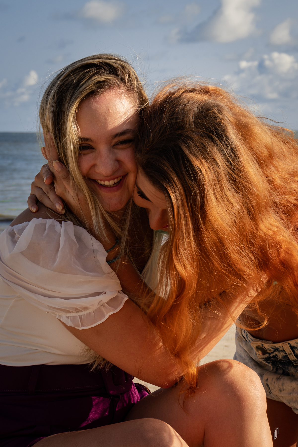 Modelo loira e ruiva na praia ao por do sol