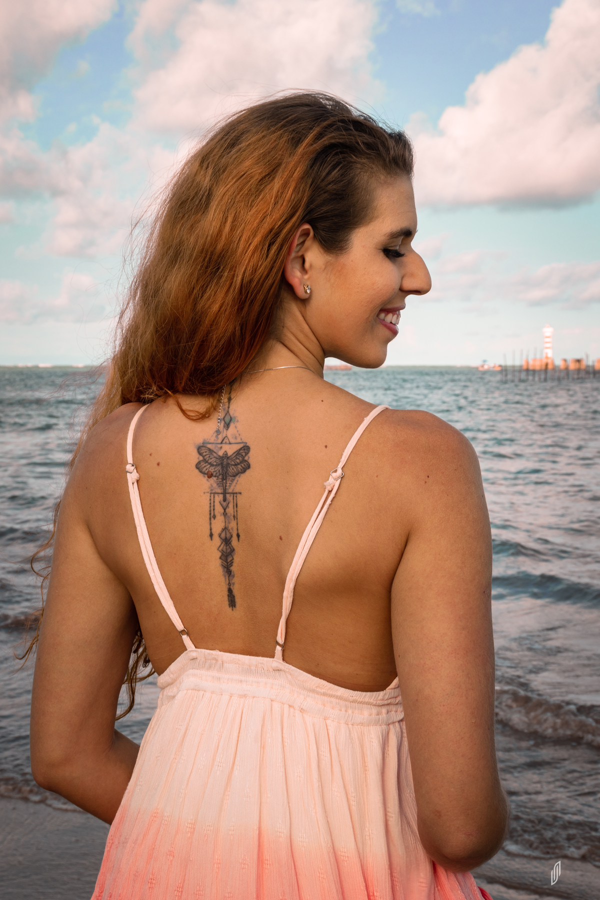 Modelo ruiva na praia ao por do sol