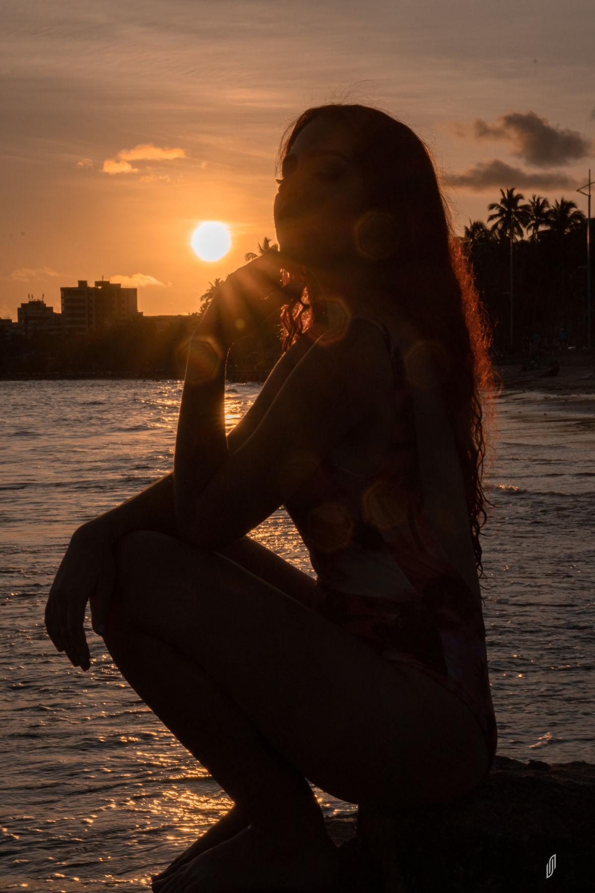 Modelo ruiva na praia ao por do sol