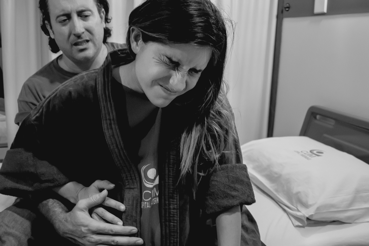 pai fazendo carinho na mãe em um parto realizado na clim em joão pessoa pelo fotografo da paraíba Jocieldes Alves