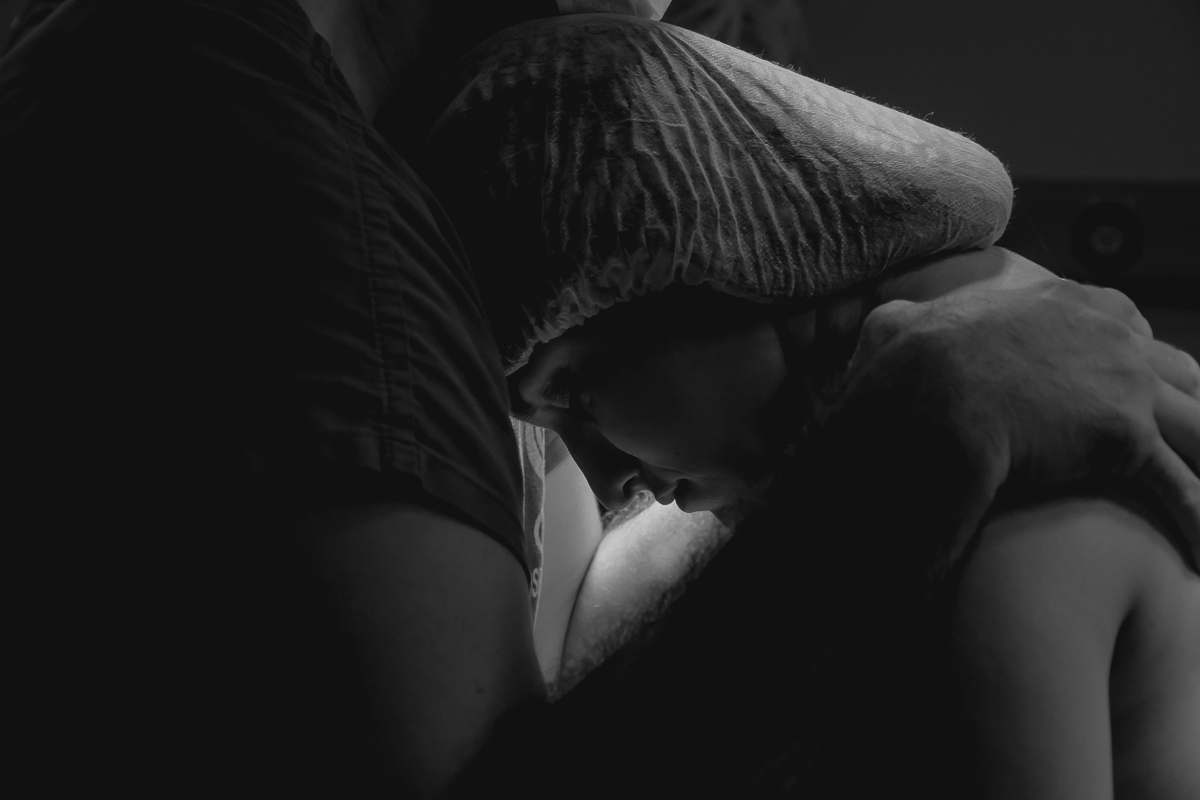 pai fazendo carinho na mãe em um parto realizado na clim em joão pessoa pelo fotografo da paraíba Jocieldes Alves