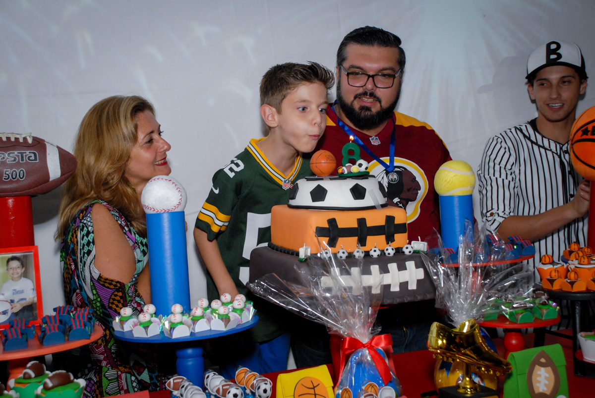 assoprando a vela do bolo no Buffet Fábrica da Alegria, Osasco, Sao Paulo, tema da festa esportes americanos, aniversariante Matheus 8 anos
