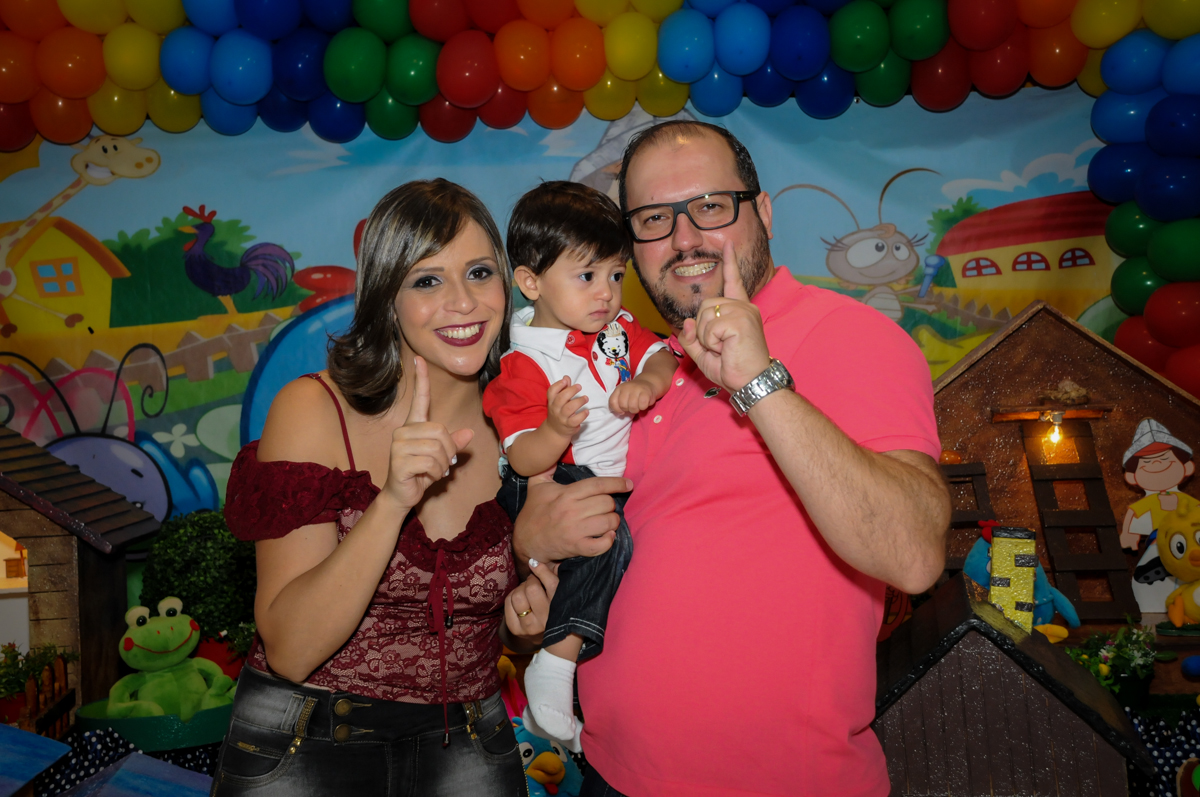 os pais são fotografados com o aniversariante no Buffet Fábrica da Alegria, Osasco, São Paulo festa infantil, tema da festa galina pintadinha Victor 1 aninho