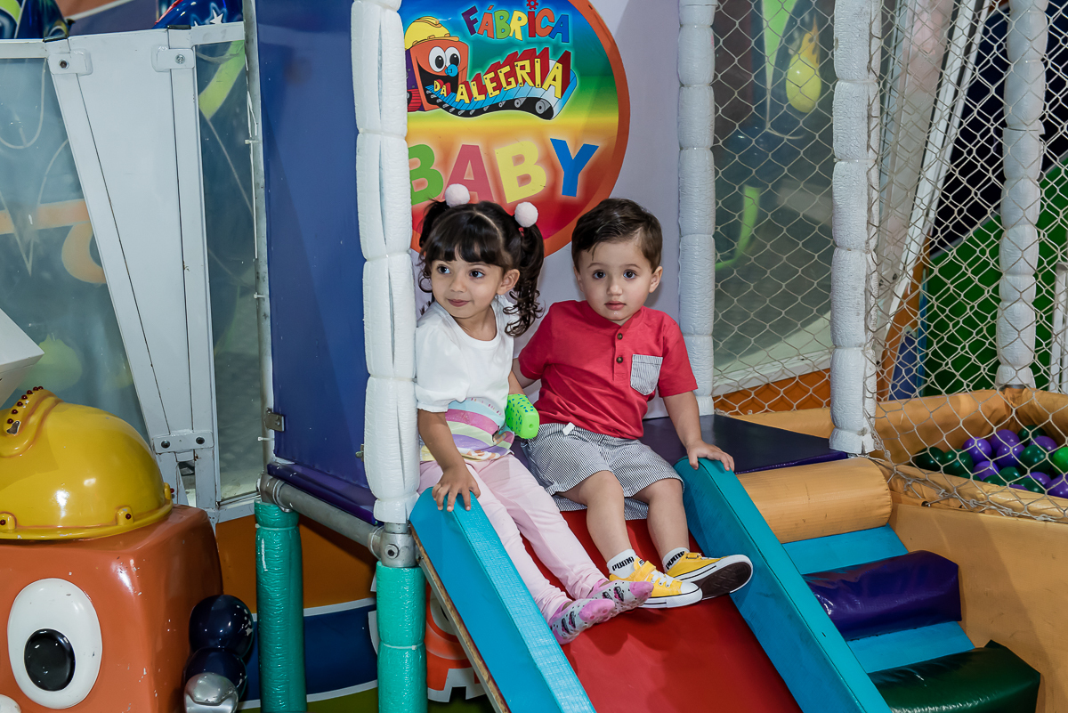 com a amiguinha o aniversariante brinca no escorregador