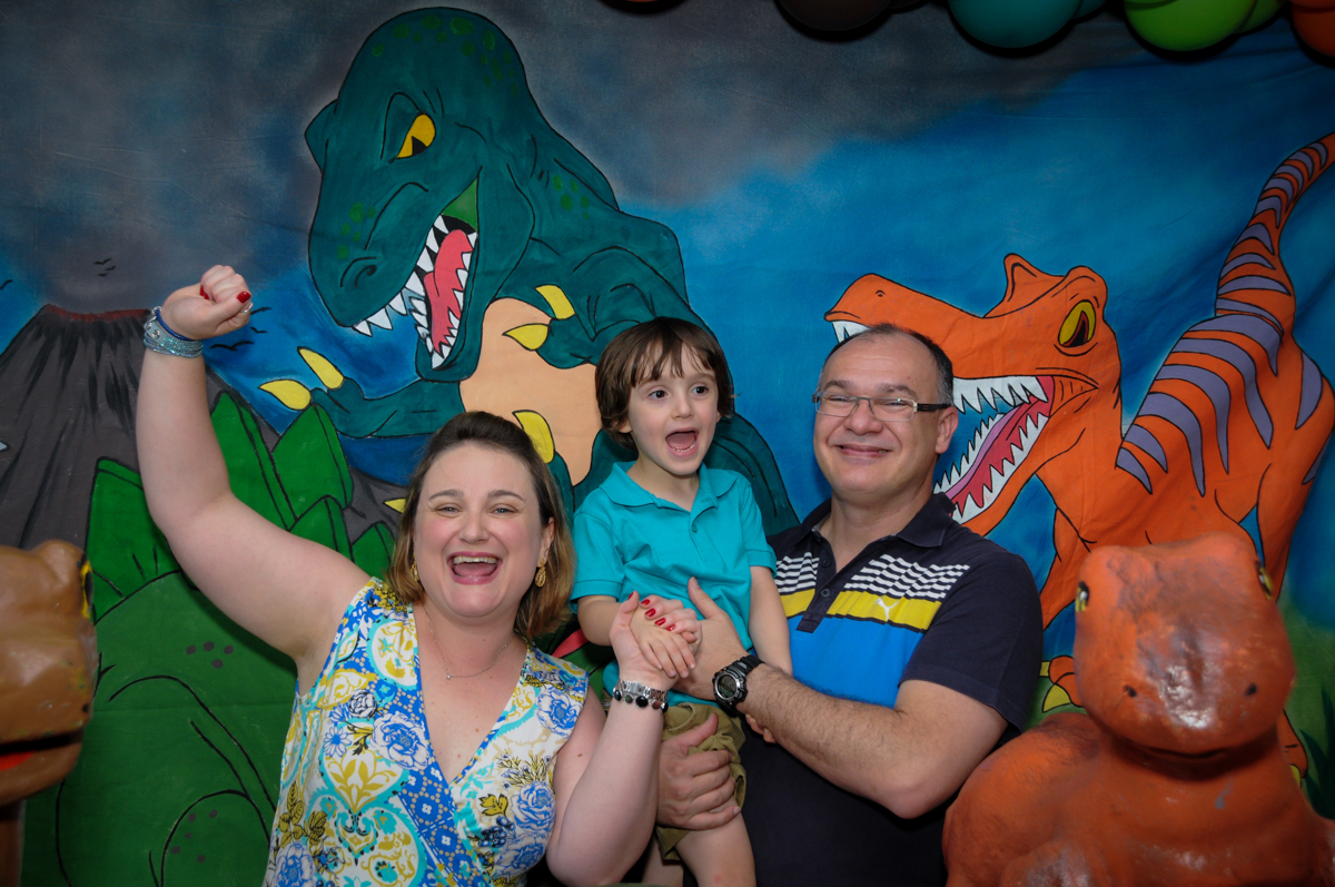 fotografia da família em frente a mesa decorada no Buffet Planeta 2, Butantã, SP, festa infantil fotografia infantil, aniversário de Fabrício 4 anos tema da mesa dinossauros