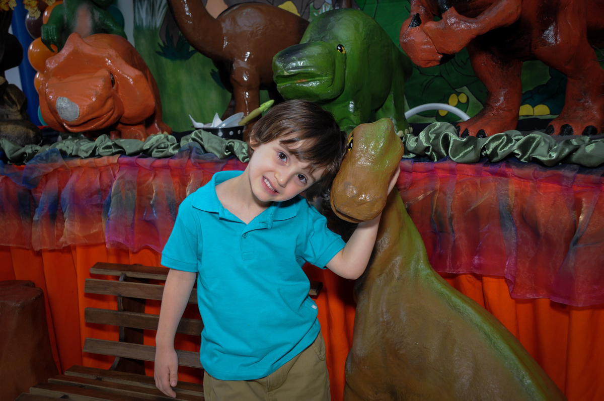 fotografia do aniversariante em frente a mesa decorada no Buffet Planeta 2, Butantã, SP, festa infantil fotografia infantil, aniversário de Fabrício 4 anos tema da mesa dinossauros