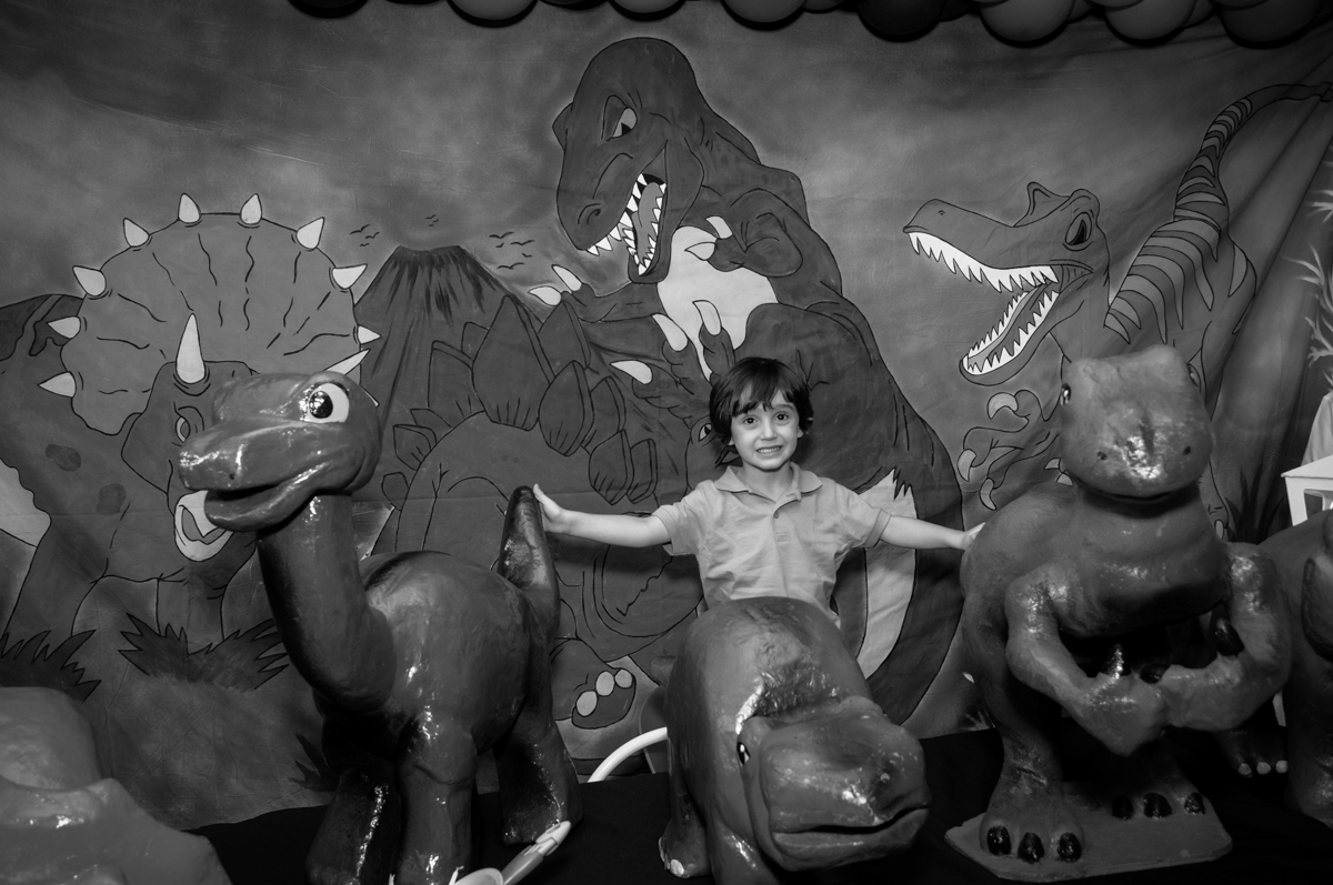 Alegria do aniversariante em sua festa no Buffet Planeta 2, Butantã, SP, festa infantil fotografia infantil, aniversário de Fabrício 4 anos tema da mesa dinossauros