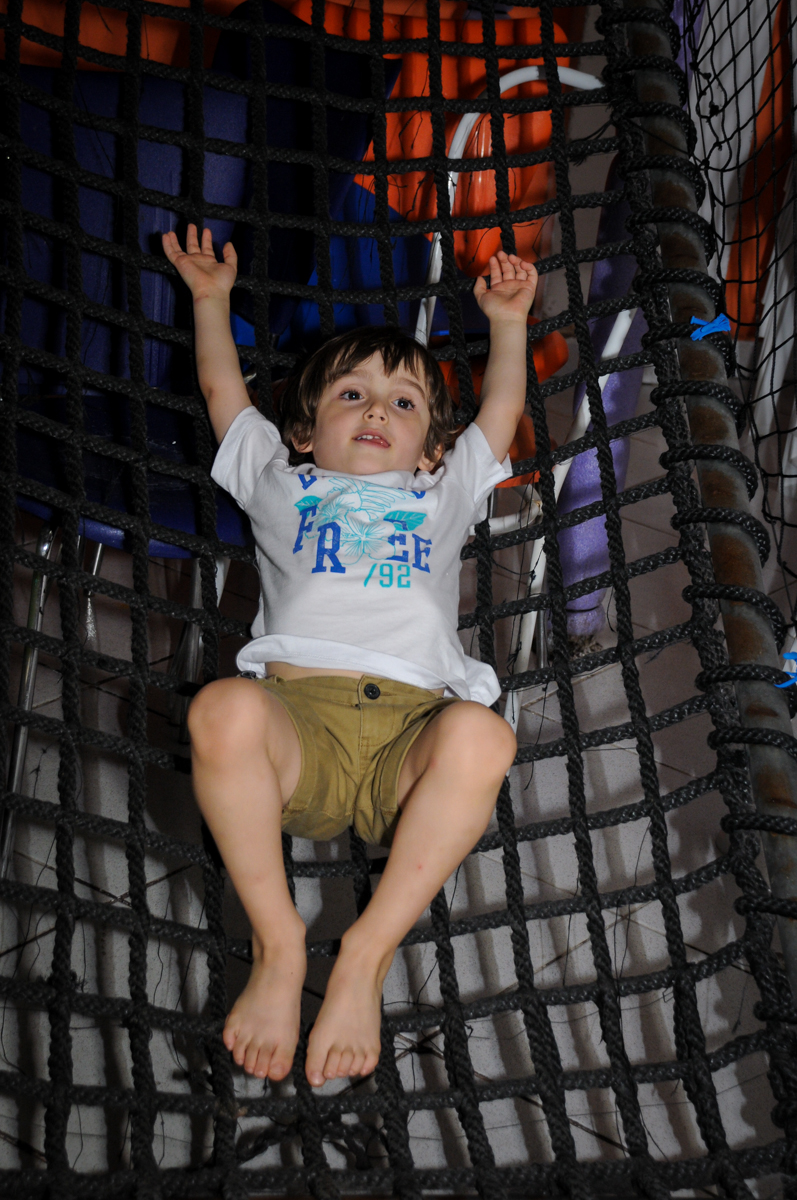 deitado relaxando no brinquedão no Buffet Planeta 2, Butantã, SP, festa infantil fotografia infantil, aniversário de Fabrício 4 anos tema da mesa dinossauros