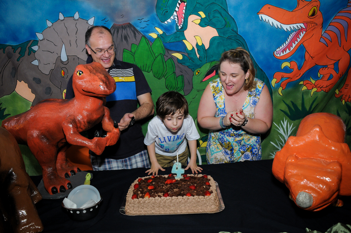 soprando a velinha do bolo no Buffet Planeta 2, Butantã, SP, festa infantil fotografia infantil, aniversário de Fabrício 4 anos tema da mesa dinossauros