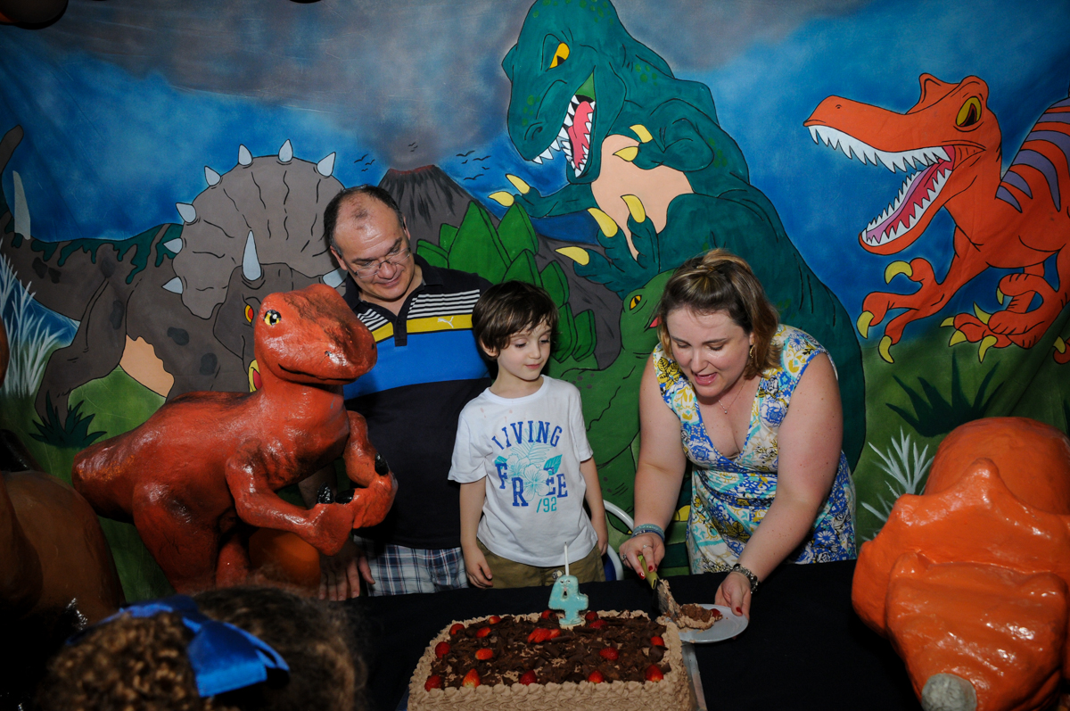 cortando o bolo, quem vai ganhar o primeiro pedaço de bolo? no Buffet Planeta 2, Butantã, SP, festa infantil fotografia infantil, aniversário de Fabrício 4 anos tema da mesa dinossauros