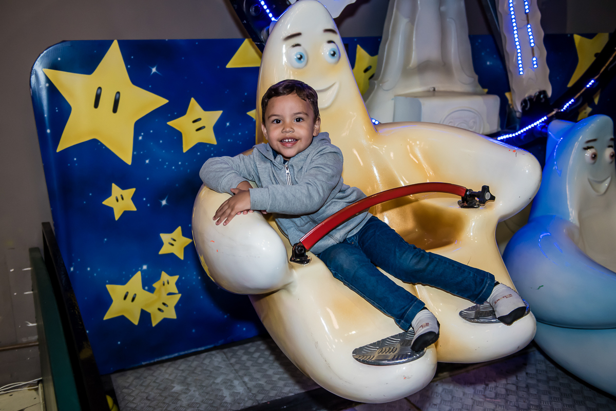 o bebe brincando muito e se divertindo no brinquedo carrossel
