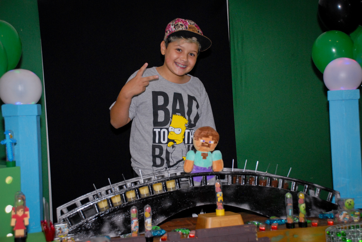 aniversariante posa para a foto na Festa infantil, festa de Vinícius 10 anos tema da mesa minicraft, no Buffet Fábrica da Alegria, Morumbi,SP