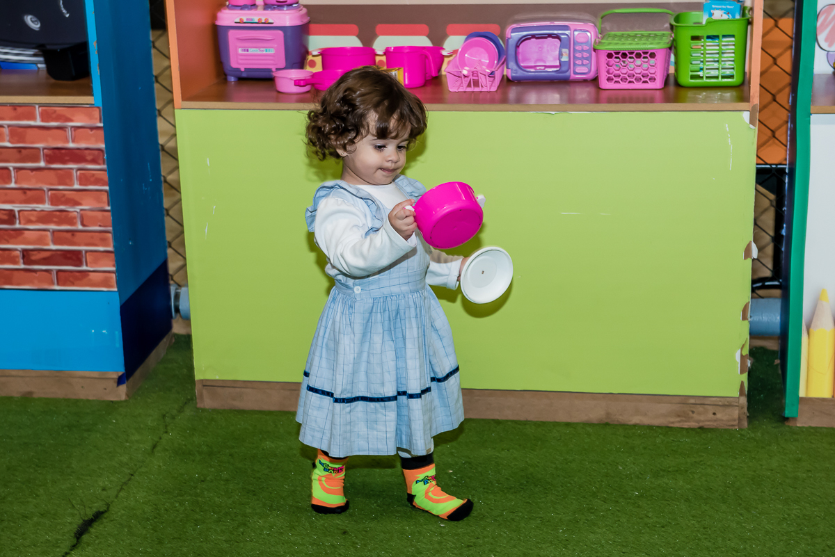 que fofa a garotinha brincando com as panelinhas da mini cozinha