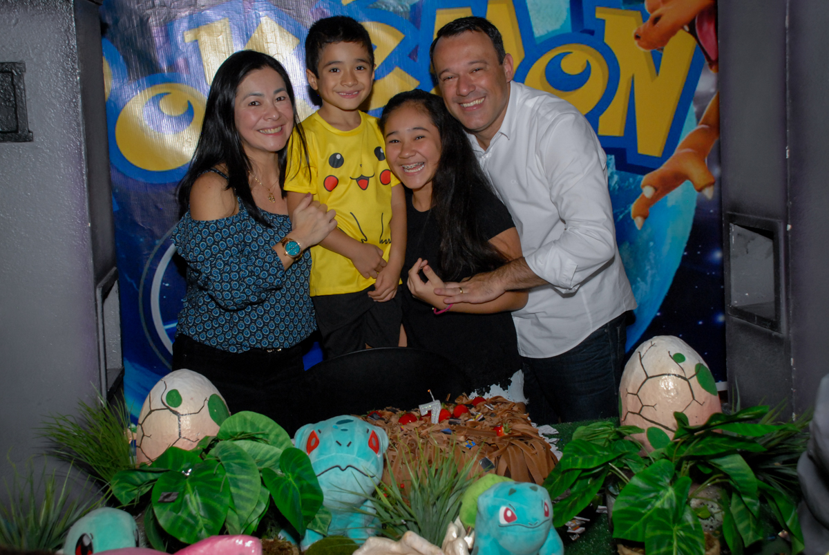 foto-da-família-na-mesa-do-parabéns-no-buffet-planeta-kids-lapa-são-paulo-sp-fotografia-filmagem-infantil-aniversário-rafael-7-anos-tema-da-festa-pokemon