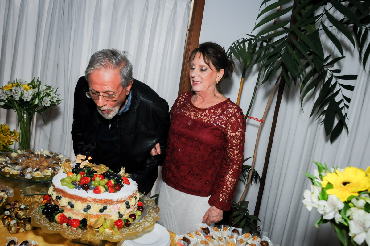 assoprando-a-vela-do-bolo-no-sítio-granja-viana-festa-adulto-bodas-de-ouro-placidia-e-eider