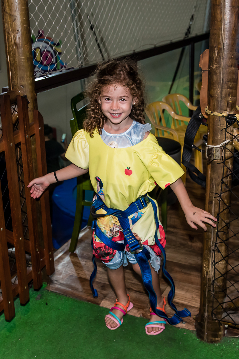 a amiguinha desce toda feliz do brinquedo arborismo