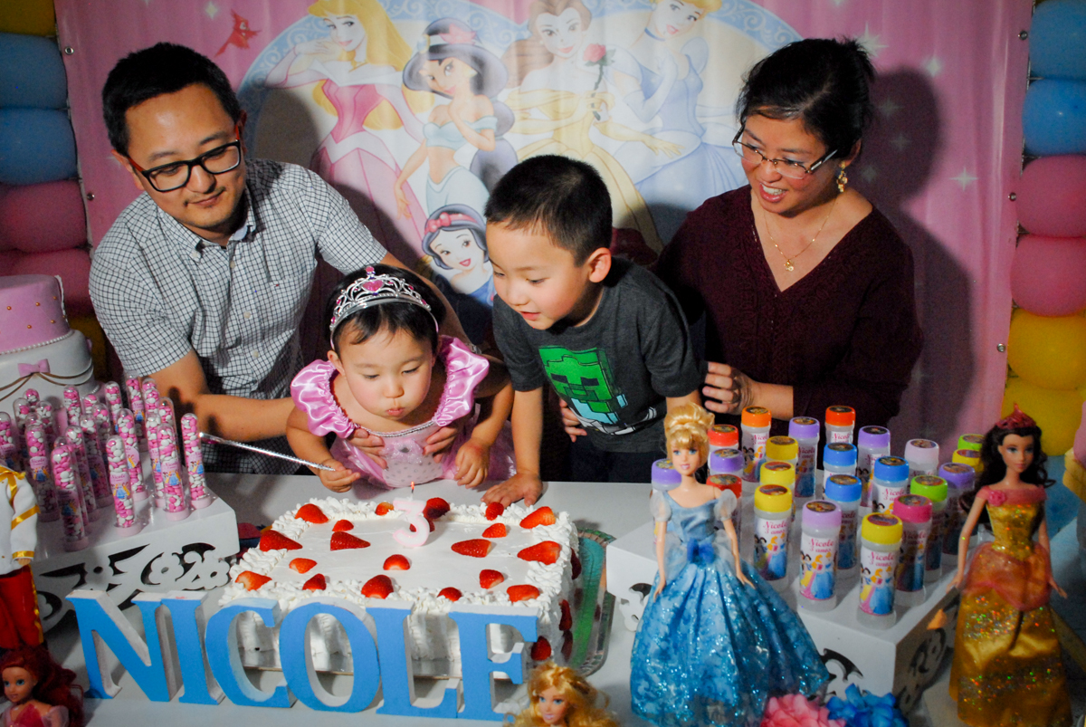 soprando a vela do bolo no condominio vila mariana aniversario de nicole 3 aninhos tema da festa princesas