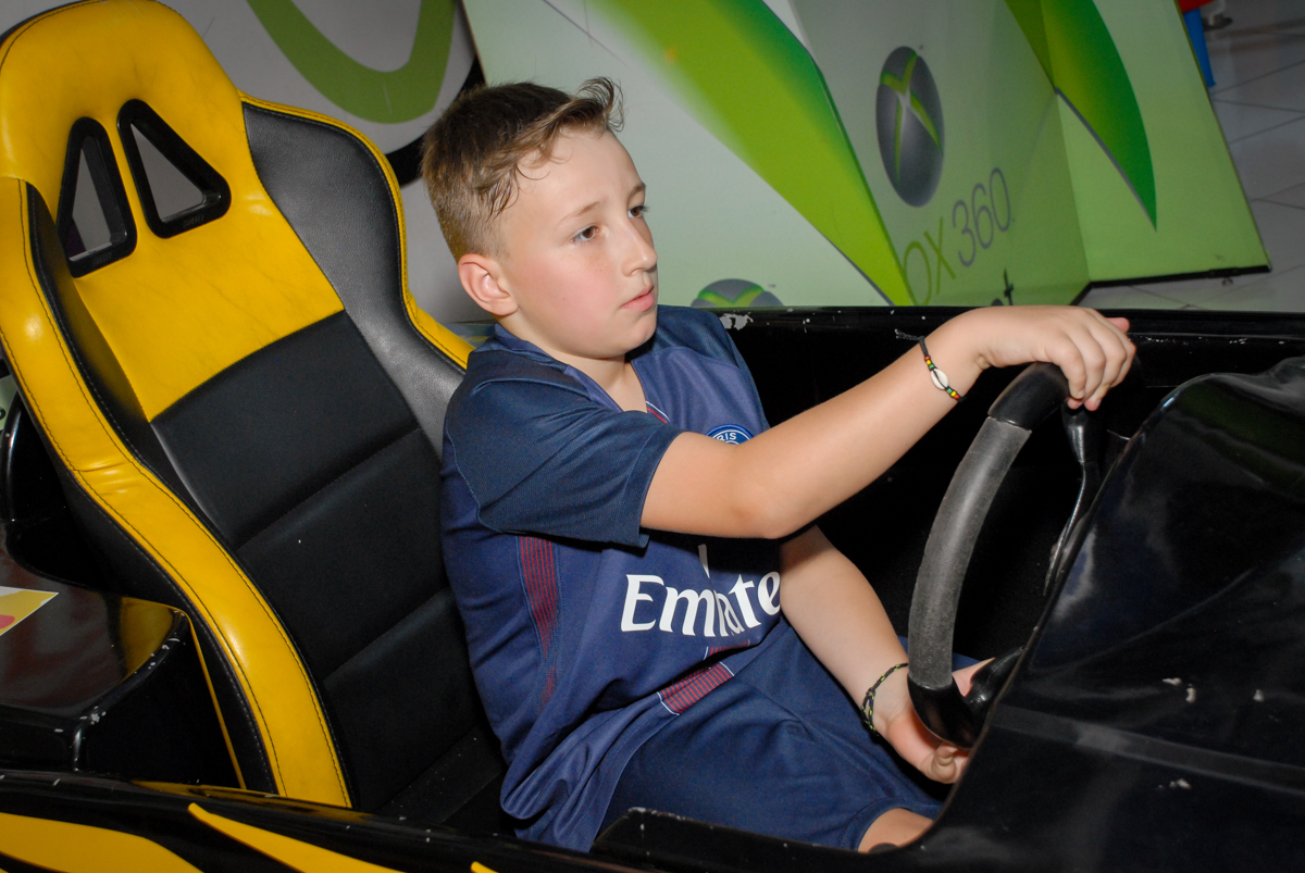 aniversariante brinca no simulador de corrida no Buffet Fábrica da Alegria, Morumbi, São Paulo aniversário de Victor 10 anos e Pedro 1 aninho, tema da festa Paris Saint Germani