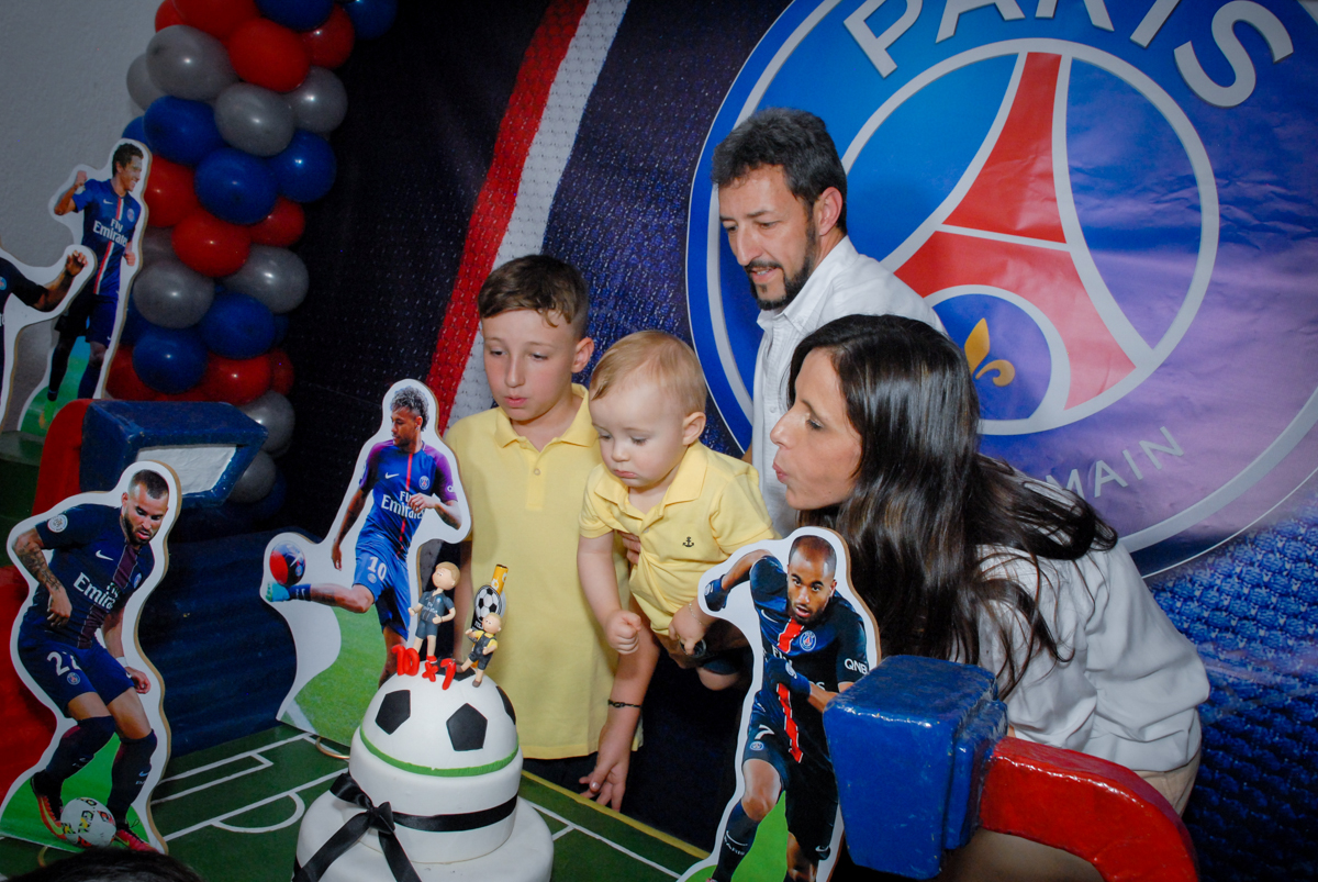 soprando a vela do bolo no Buffet Fábrica da Alegria, Morumbi, São Paulo aniversário de Victor 10 anos e Pedro 1 aninho, tema da festa Paris Saint Germani