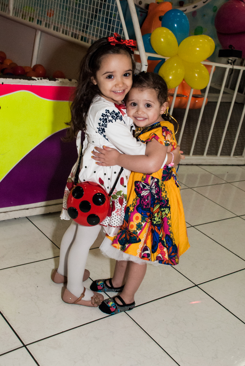 recebendo a amiga com abraço no Buffet Lacorte, Tatuapé, São Paulo aniversário de Luiza 3 anos, tema da festa A Bela e a Fera