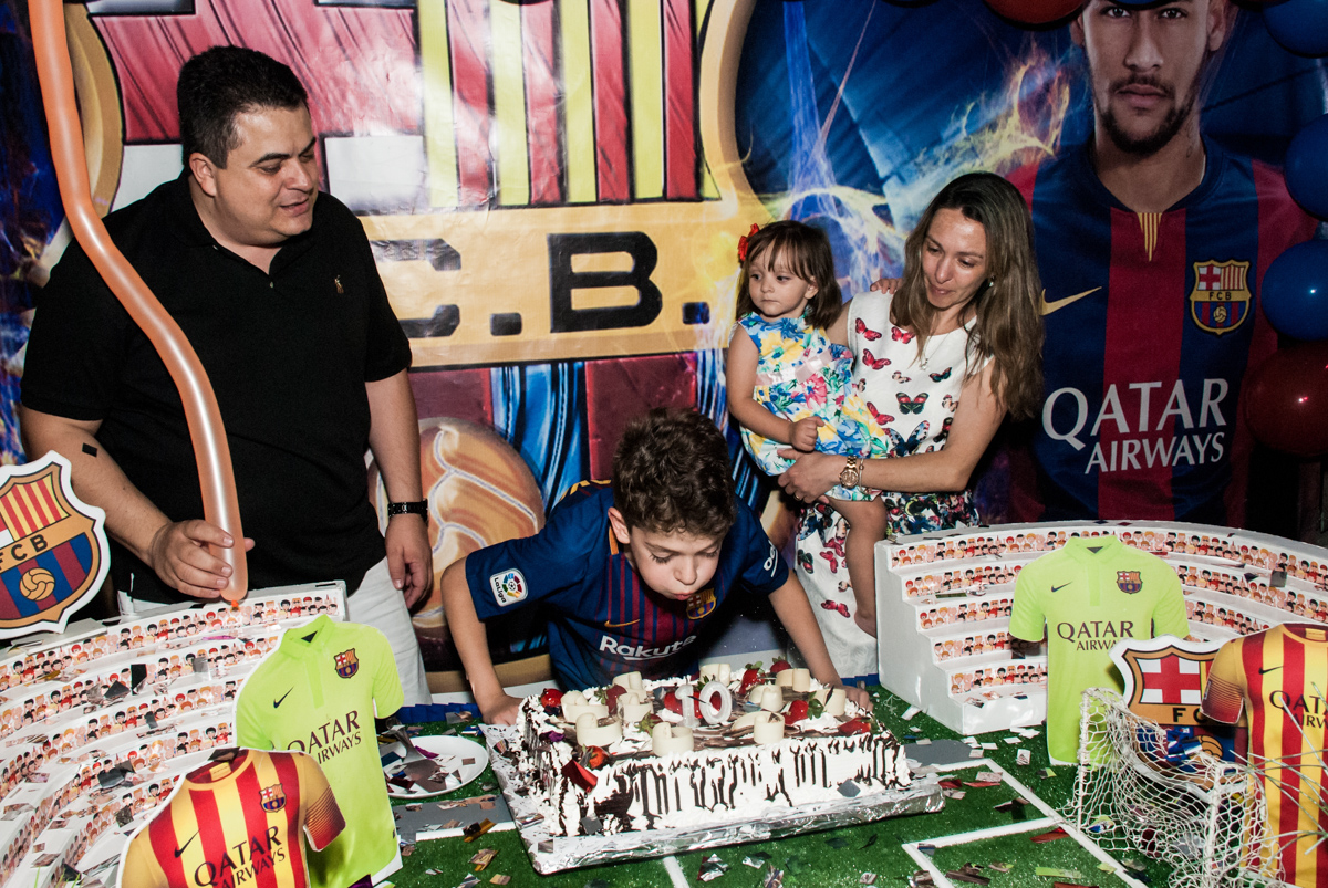 soprando a vela do bolo no Buffet Planeta Kids, aniversário de Gustavo 10 anos, tema da festa Barcelona