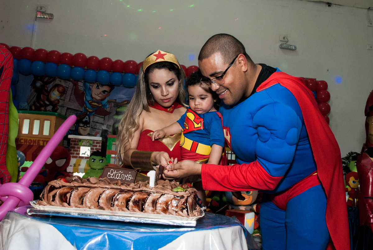 cortando o primeiro pedaço de bolo no buffet Zezé e Lelé, aniversário de Otávio 1 ano, tema da festa heróis baby