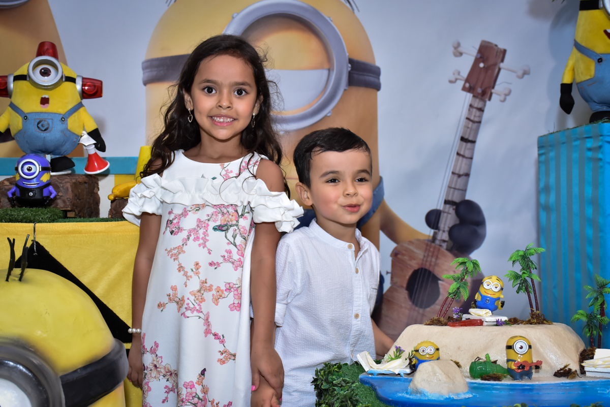 foto dos irmãos na mesa temática no Buffet Fábrica da Alegria, Osasco, São Paulo, tema da festa, meu malvado favorito