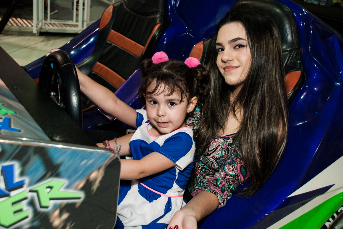 brincando no simulador de corridas no Buffet Fábrica da Alegria, Osasco, São Paulo, aniversário de anna clara, 3 anos, tema da festa Frozen