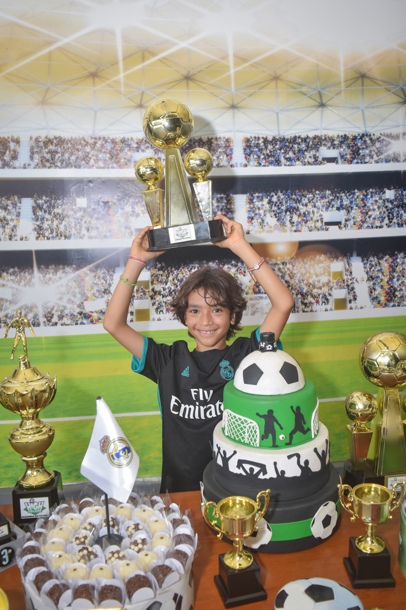 erguendo a taça no buffet High Soccer aniversario de João Pedro 8 anos, tema da festa Real Madrid