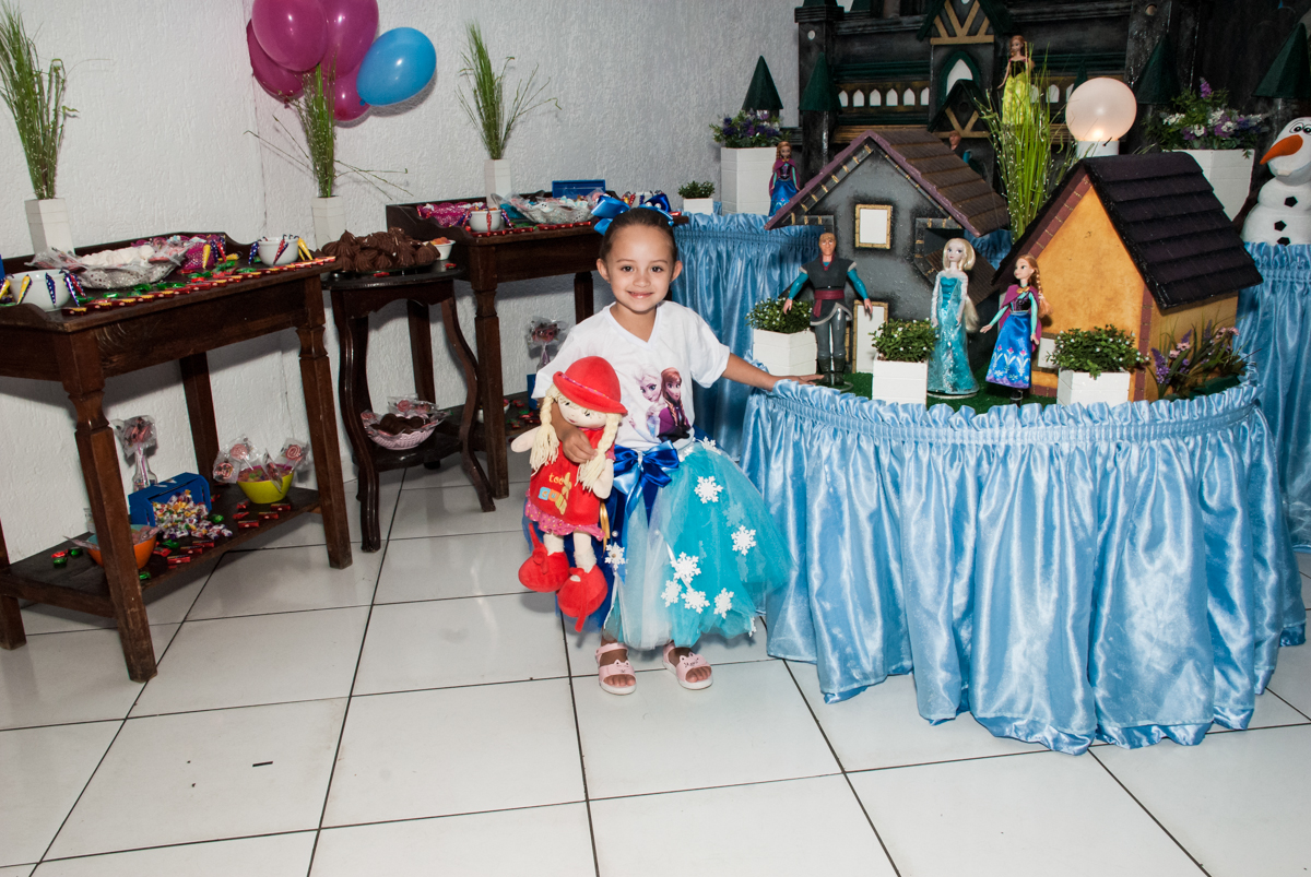 aniversariante faz foto em frente a mesa decorada no Buffet Fábrica da Alegria Morumbi, anieversário de Ana Julia 3 anos, tema da festa Frozen