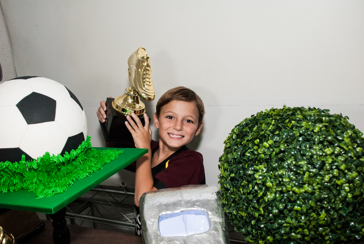 aniversariante segura o troféu no Buffet Fábrica da Alegria, Morumbi, São Paulo, aniversário de Beatriz e Miguel 8 anos, tema da festa Unicórnio e Futebol