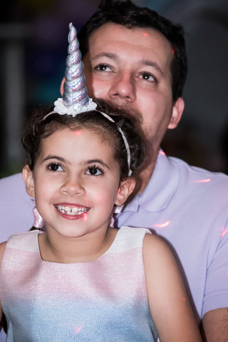 feliz vendo a retrospectiva no Buffet Planeta Kids, Lapa, São Paulo, aniversario de Sarah 8 anos, tema da festa Unicórnio