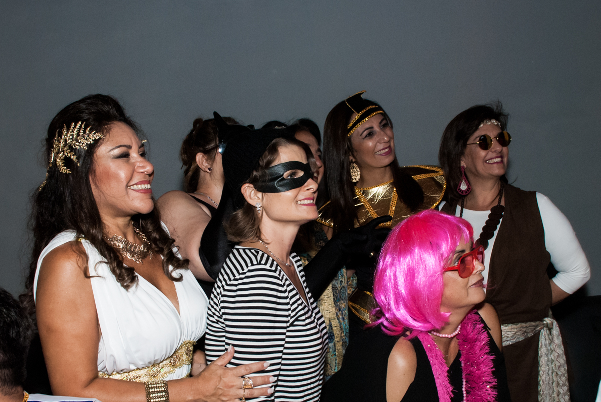 assistindo a retrospectiva na festa adulto aniversário de Da Silva 60 anos, tema da festa fantasia