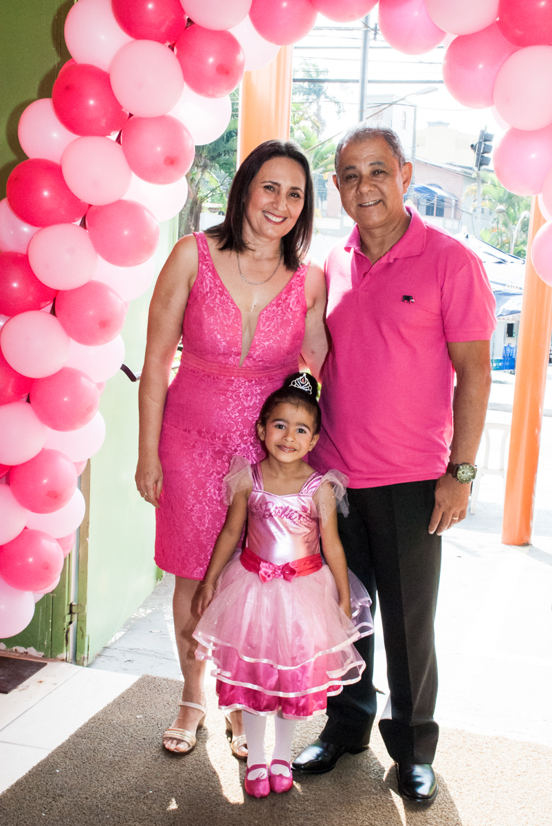 A família sendo fotografada no arco de bexigas