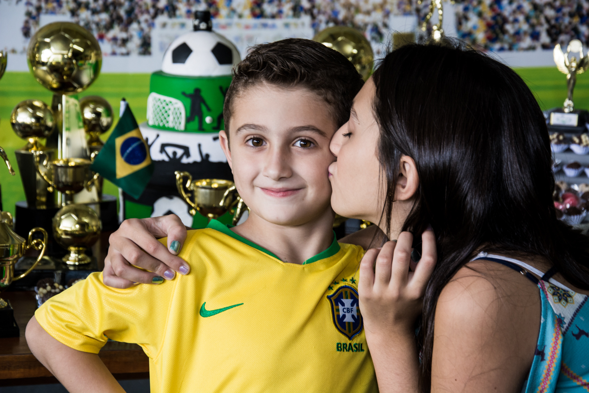 O aniversariante ganha beijo da irmã