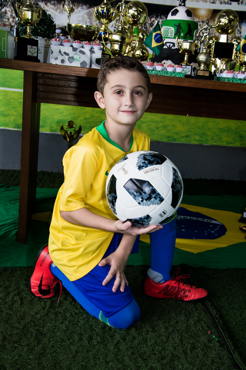 faz pose de jogador com a bola para a foto