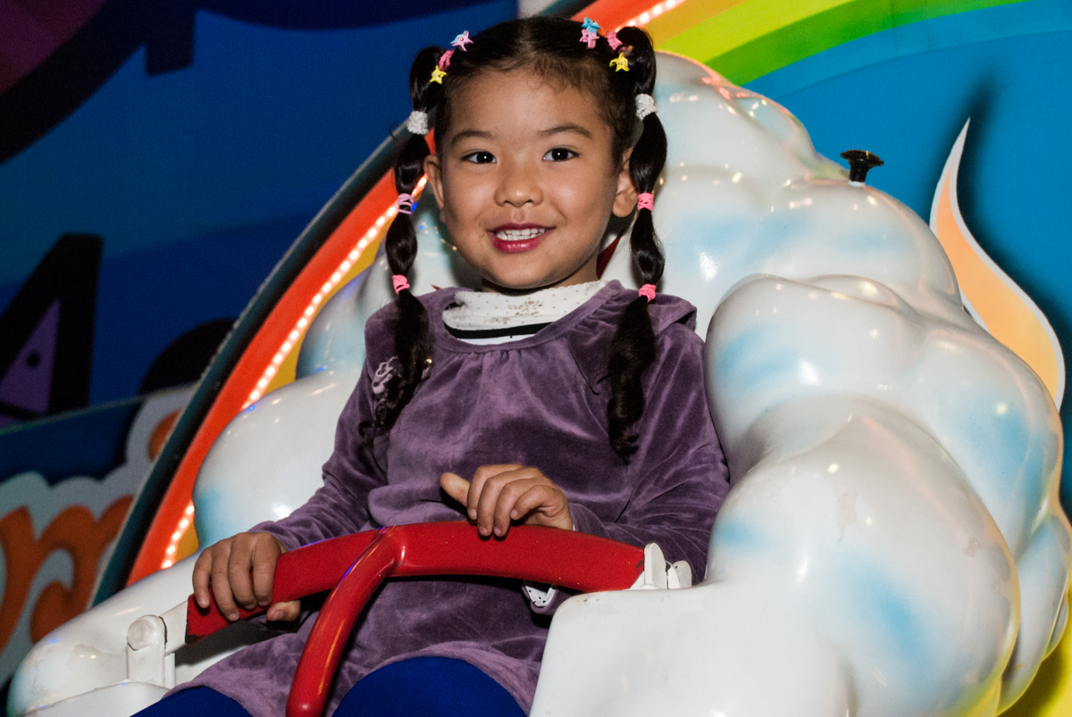 linda menina de brança brincando no carrossel