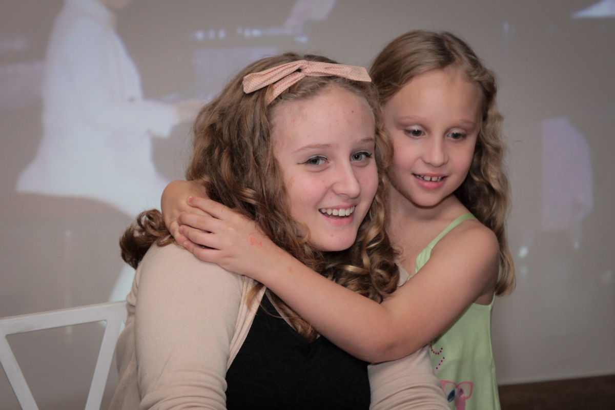 As irmãs curtem a festa de aniversário de seu pai