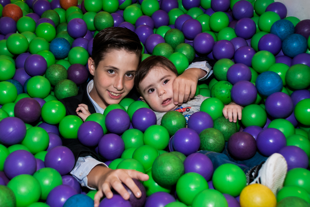 brincadeira divertida com o irmão na piscina de bolinhas