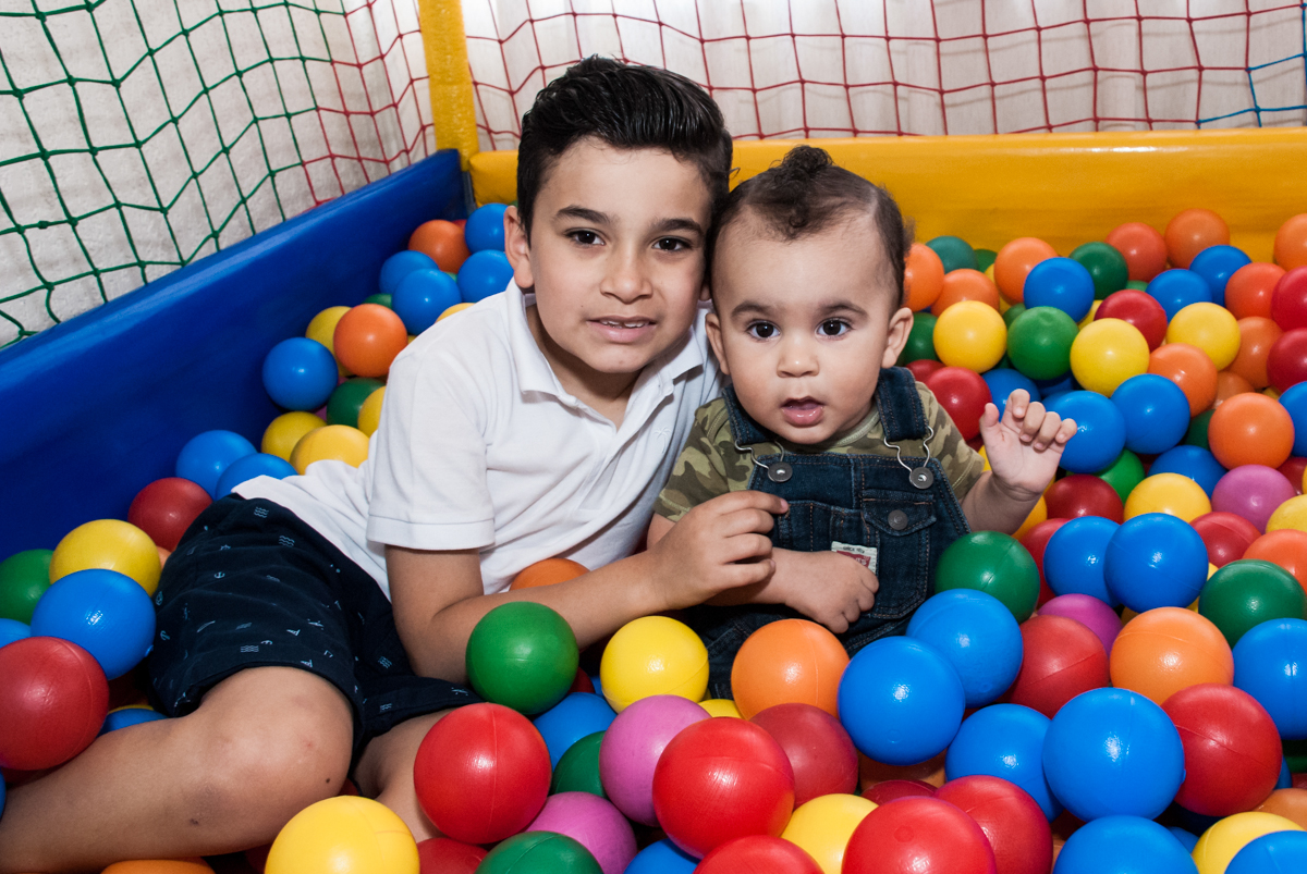 irmão e filho brincam na piscina de bolinhas