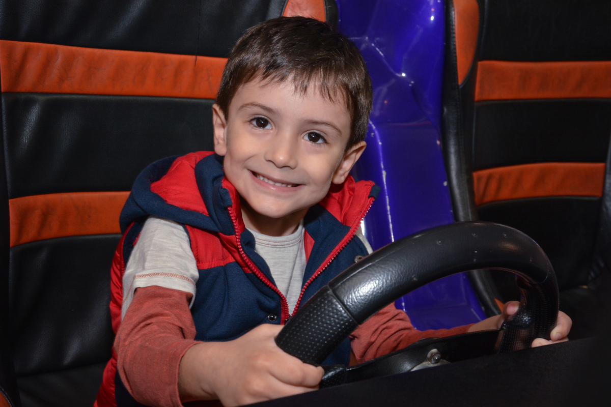 O convidado amgo também brinca no simulador de corridas