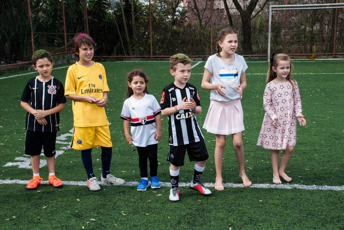 Os amigos brincam no campo de futebol