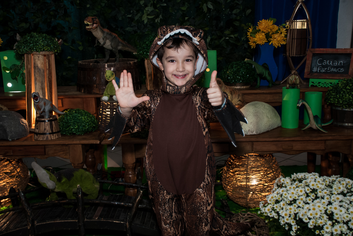 aniversariante posa para a festa na mesa temática