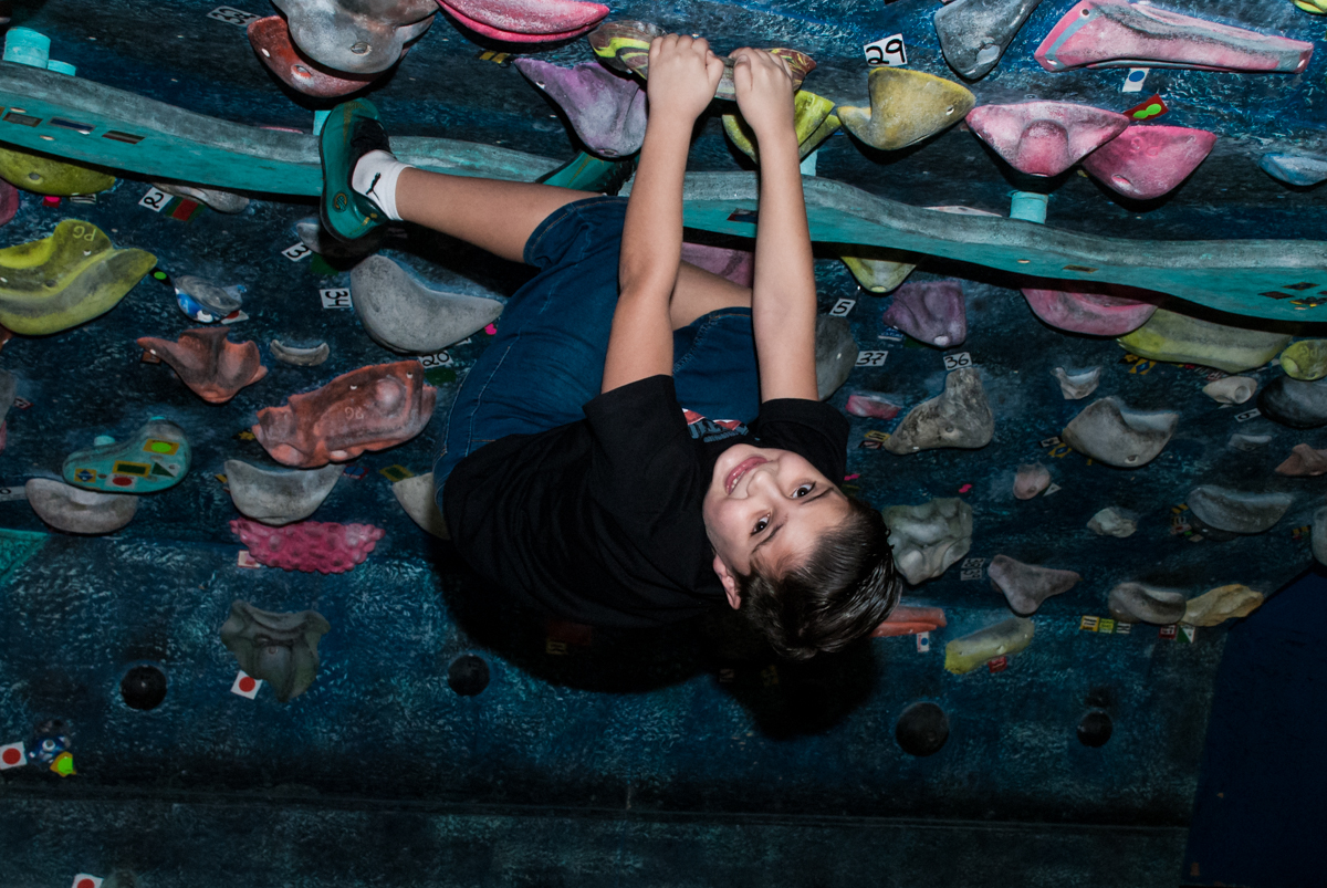 de ponta cabeça grudado na parede de escalada