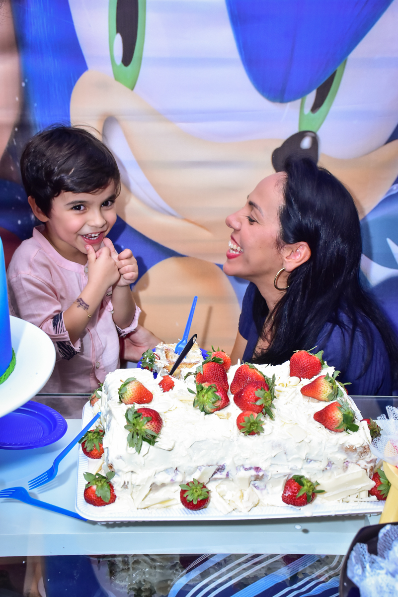 mãe feliz em receber o primeiro pedaço do bolo