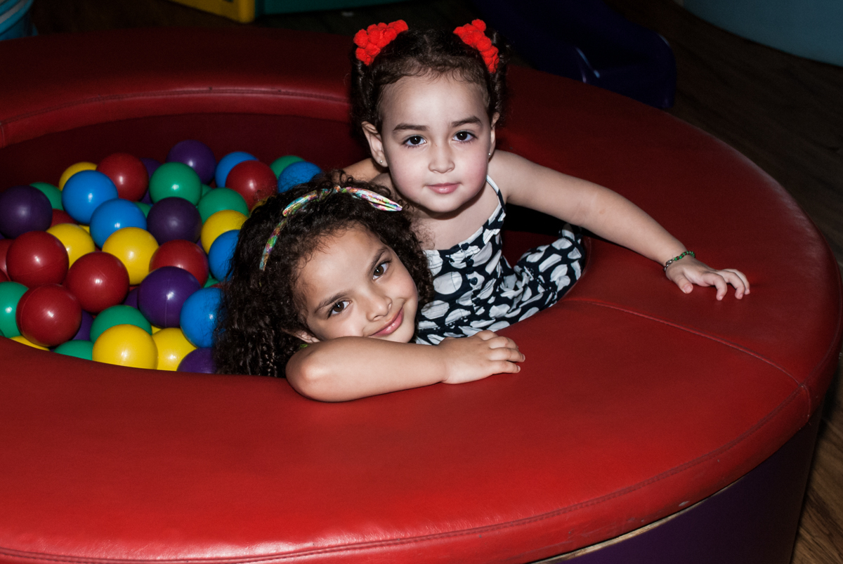 As amigas brincam na piscina de bolinhas