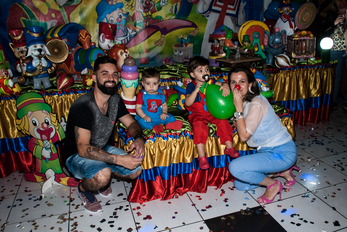 Os pais com os aniversariantes muito felizes no final da festa